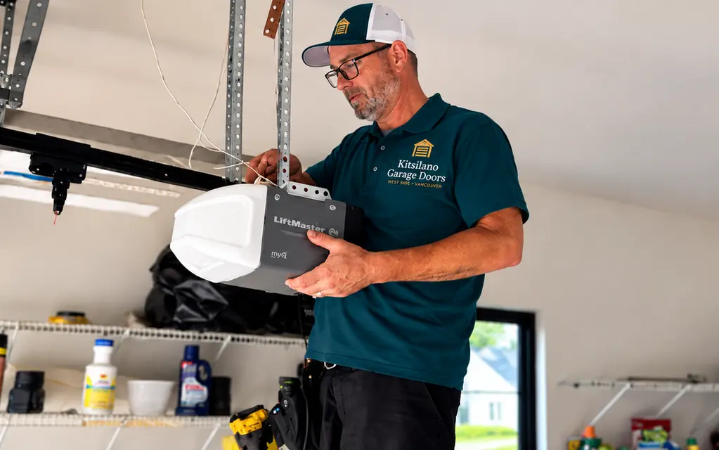 Kitsilano Garage Doors technician installing a LiftMaster myQ belt-drive opener on a garage ceiling